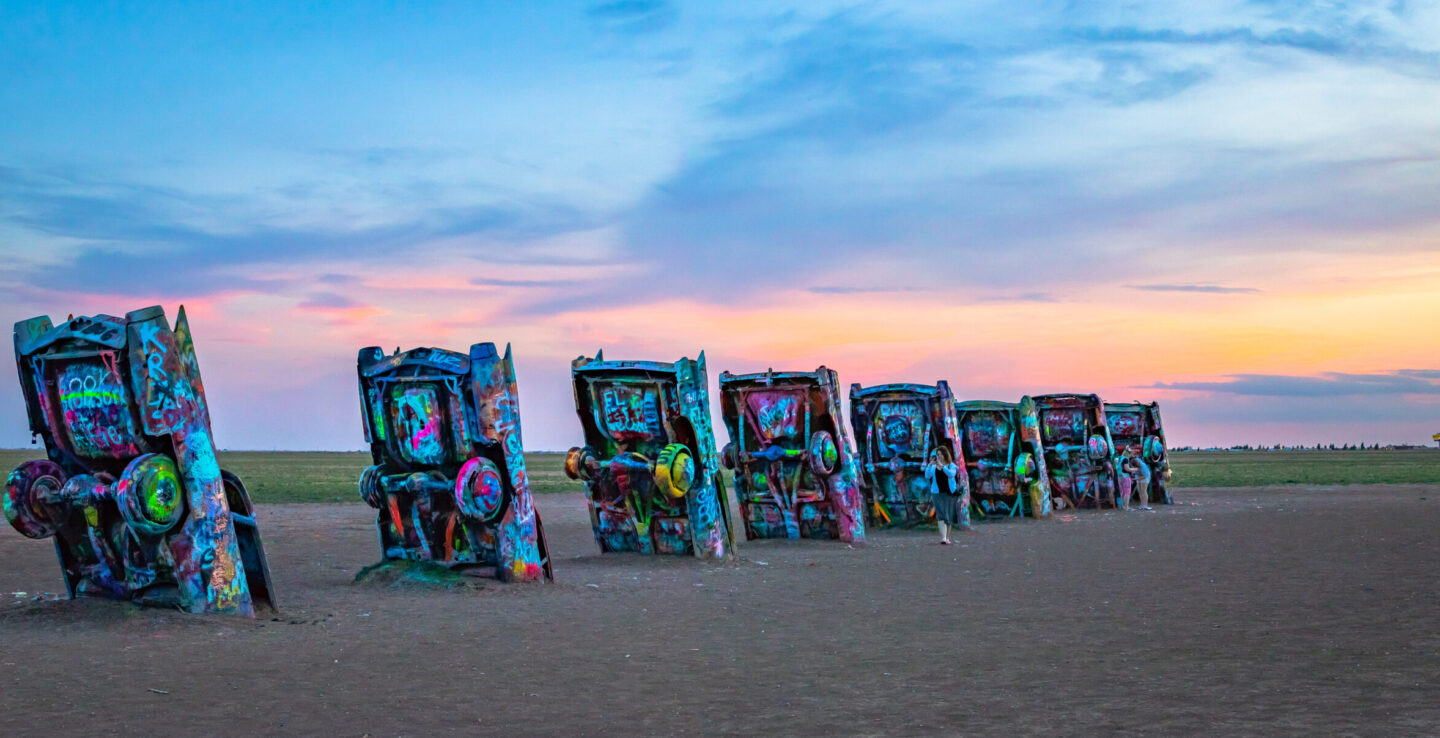 Vue au coucher du soleil sur les voitures colorées à demi enfouies du Cadillac Ranch, à Amarillo, au Texas