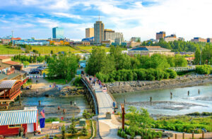 십 크릭에서 낚시하기, 배경에는 알래스카주(Alaska) 앵커리지(Anchorage) 시내 풍경이 보여요.
