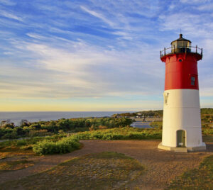 A lighthouse on Cape Cod under cloud-streaked skies