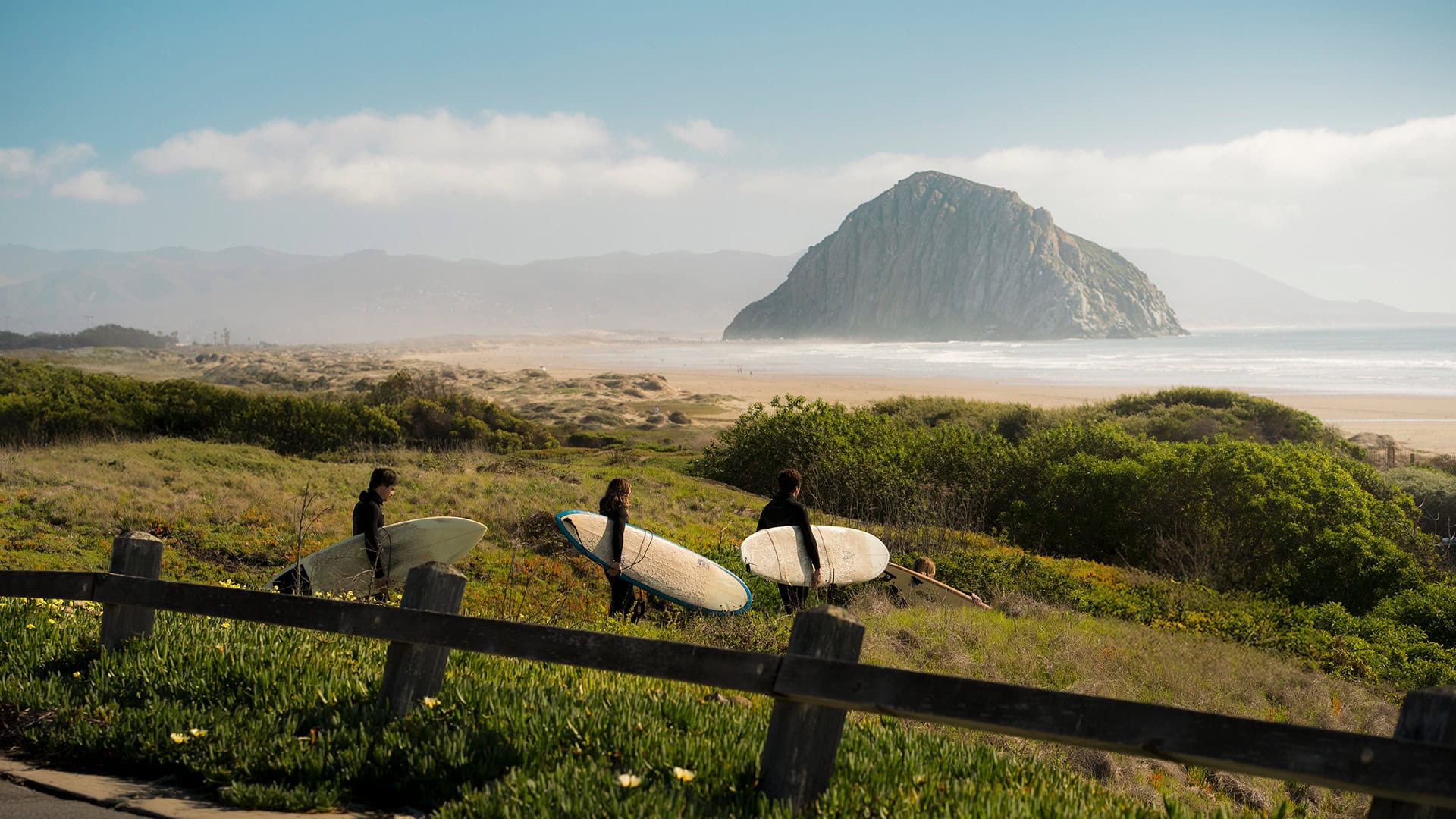 Dei surfisti diretti a Morro Strand State Beach a Morro Bay, California; Credito: Visit SLO CAL